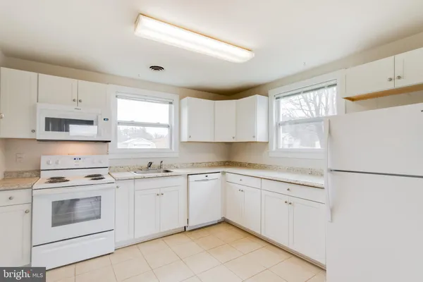 a kitchen with a stove sink and cabinets