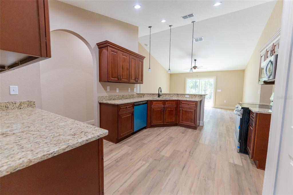 5845 Northwest 65th Street Ocala, FL 34482 - Photo 17 of 63 a kitchen with stainless steel appliances granite countertop a sink a stove and a refrigerator