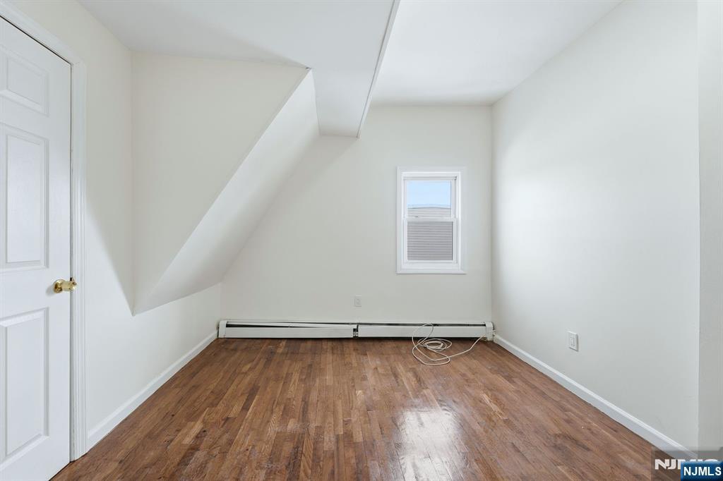 72 South 13th Street Newark, NJ 07107 - Photo 23 of 40 an empty room with wooden floor and white walls