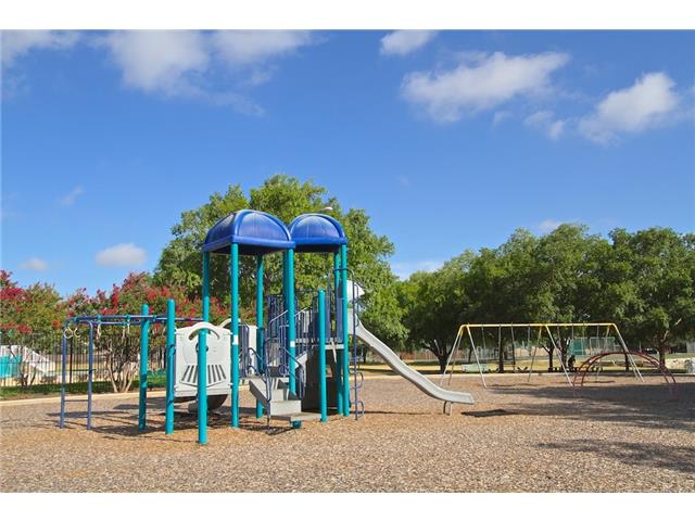 7006 Rambollet Terrace Round Rock, TX 78681 - Photo 32 of 38 A vibrant playground set amidst natural surroundings, perfect for outdoor recreation.