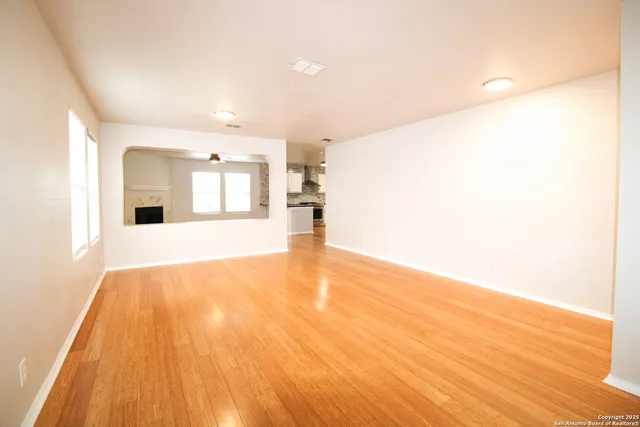 a view of a kitchen with wooden floor and a large window