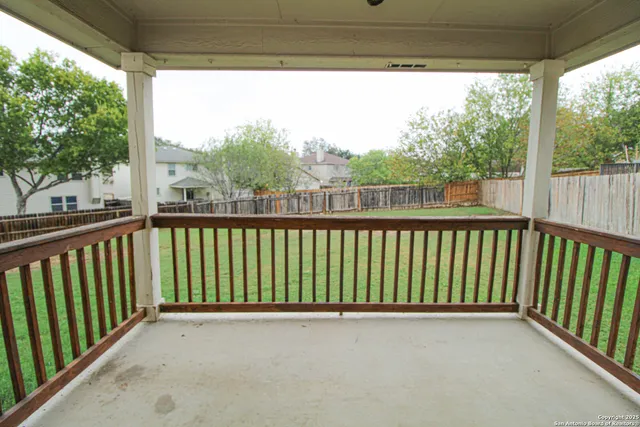 a view of a swimming pool with a lawn chairs and large trees