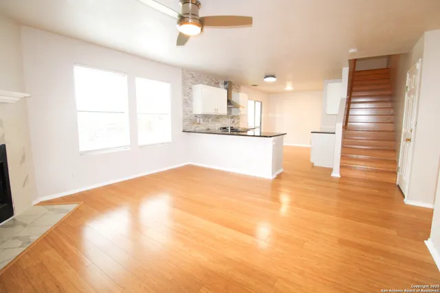 a view of a kitchen with wooden floor and a window