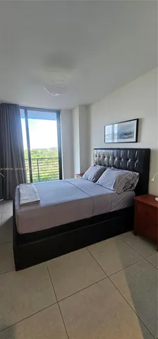 a bedroom with a bed and a dresser next to a window