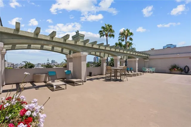 a view of roof deck with chair and tables
