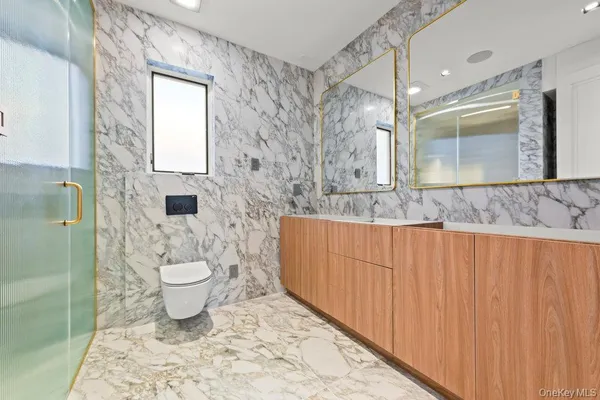 a bathroom with a granite countertop sink toilet a mirror and shower