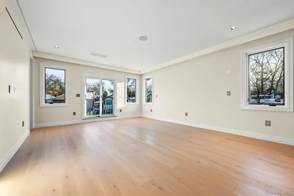 a view of a big room with wooden floor and windows