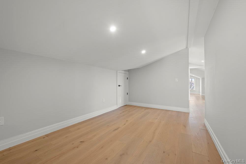 176-12 Kildare Road Queens, NY 11432 - Photo 28 of 34 Empty room with light wood-type flooring, vaulted ceiling, and recessed lighting
