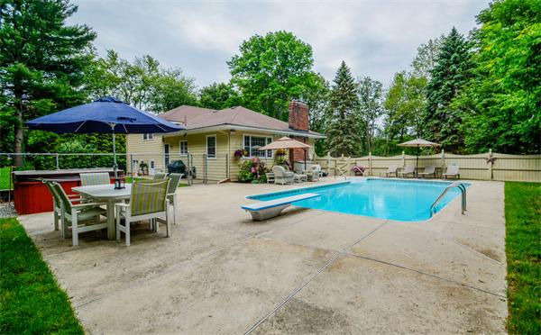 48 Prospect Road Andover, MA 01810 - Photo 19 of 23 a view of a swimming pool with lawn chairs under an umbrella