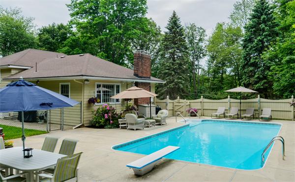 48 Prospect Road Andover, MA 01810 - Photo 3 of 23 a view of a swimming pool with lawn chairs under an umbrella