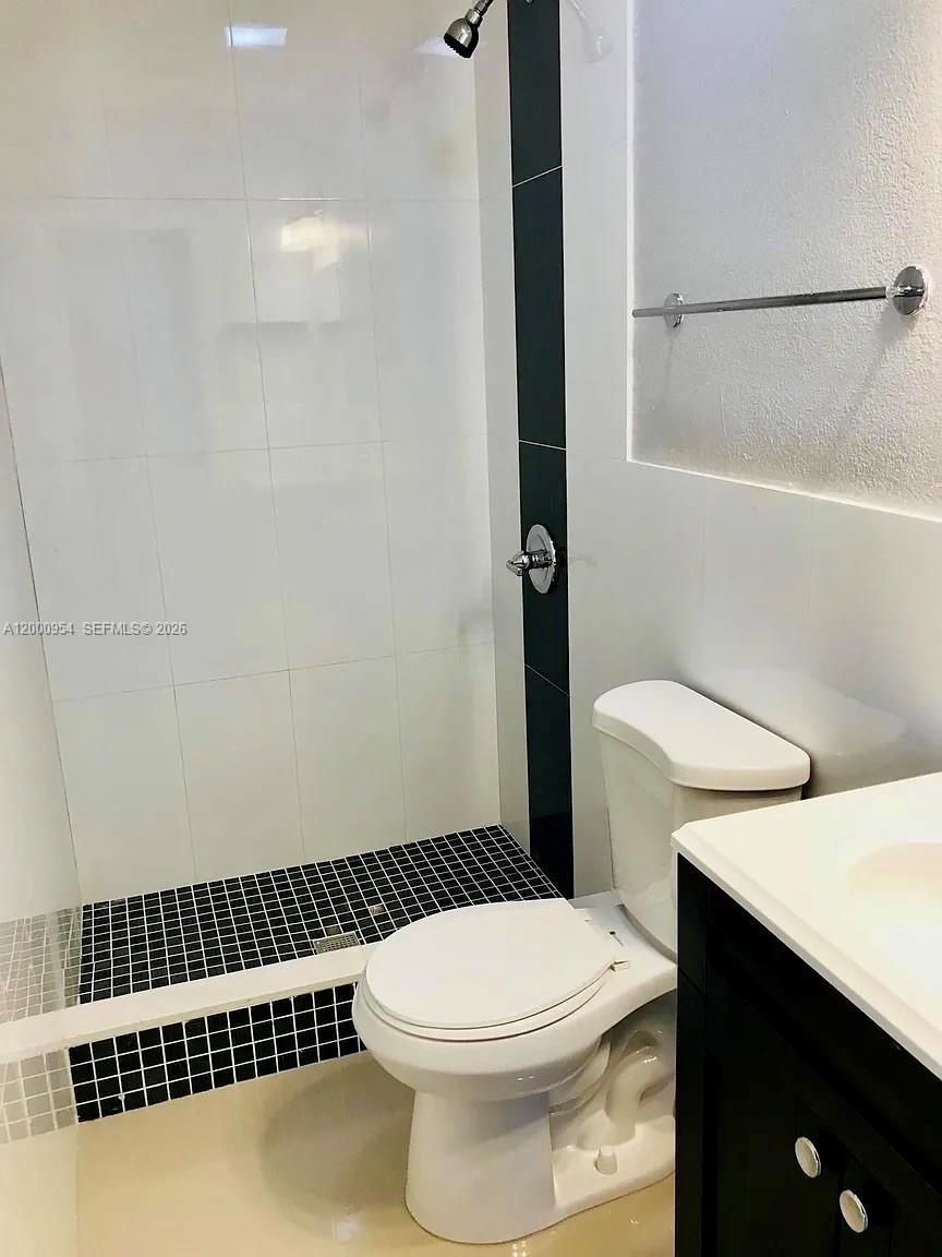 535 Northeast 68th Street, Unit UPSTAIRS Miami, FL 33138 - Photo 11 of 14 a white toilet sitting next to a bathroom sink
