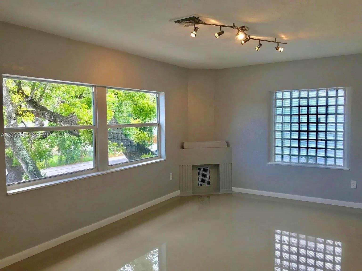 535 Northeast 68th Street, Unit UPSTAIRS Miami, FL 33138 - Photo 2 of 14 en empty room with windows and fireplace