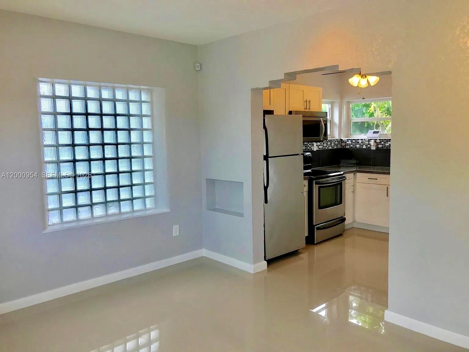 535 Northeast 68th Street, Unit UPSTAIRS Miami, FL 33138 - Photo 3 of 14 a kitchen with stainless steel appliances a refrigerator and a stove top oven