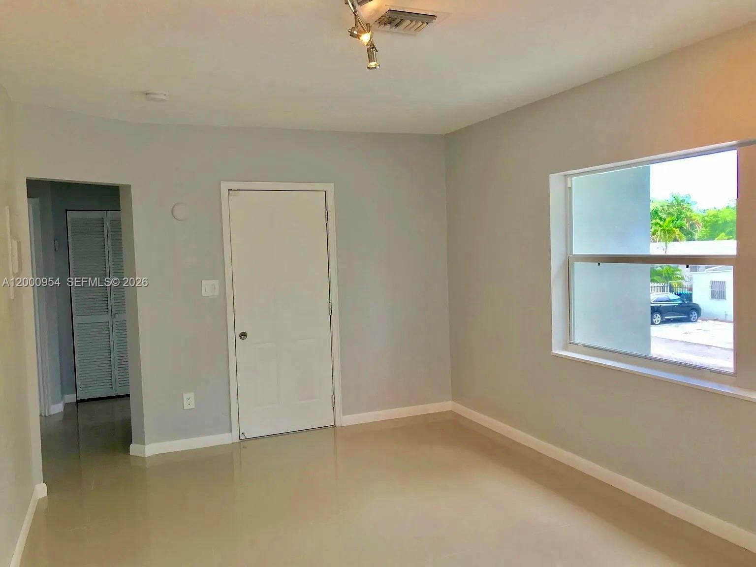 535 Northeast 68th Street, Unit UPSTAIRS Miami, FL 33138 - Photo 9 of 14 an empty room with a window