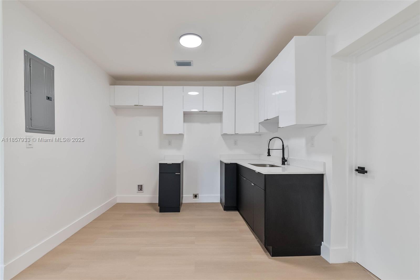 1366 Northwest 75th Street Miami, FL 33147 - Photo 15 of 26 a kitchen with white cabinets sink and stove