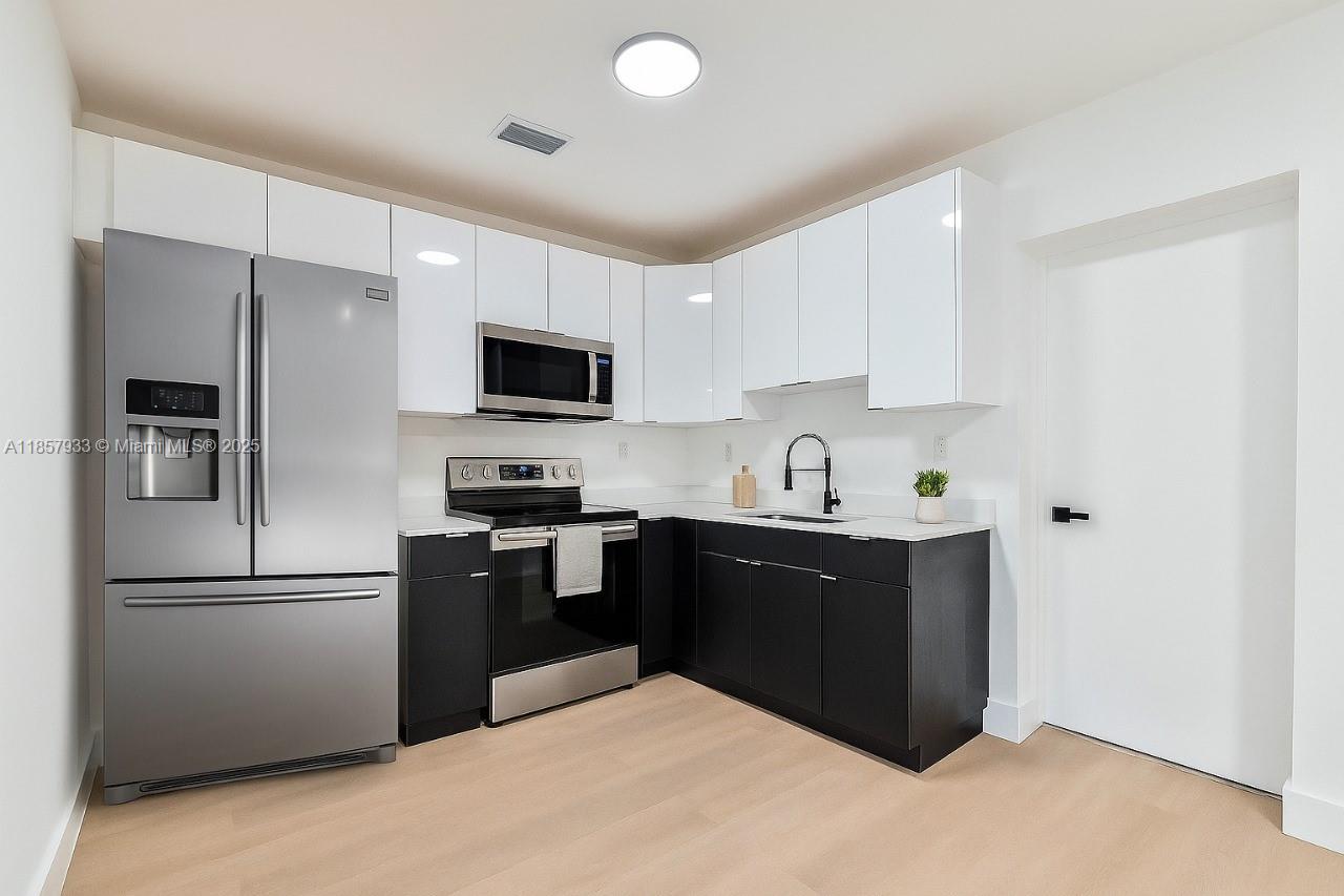 1366 Northwest 75th Street Miami, FL 33147 - Photo 4 of 26 a kitchen with granite countertop a refrigerator and a sink