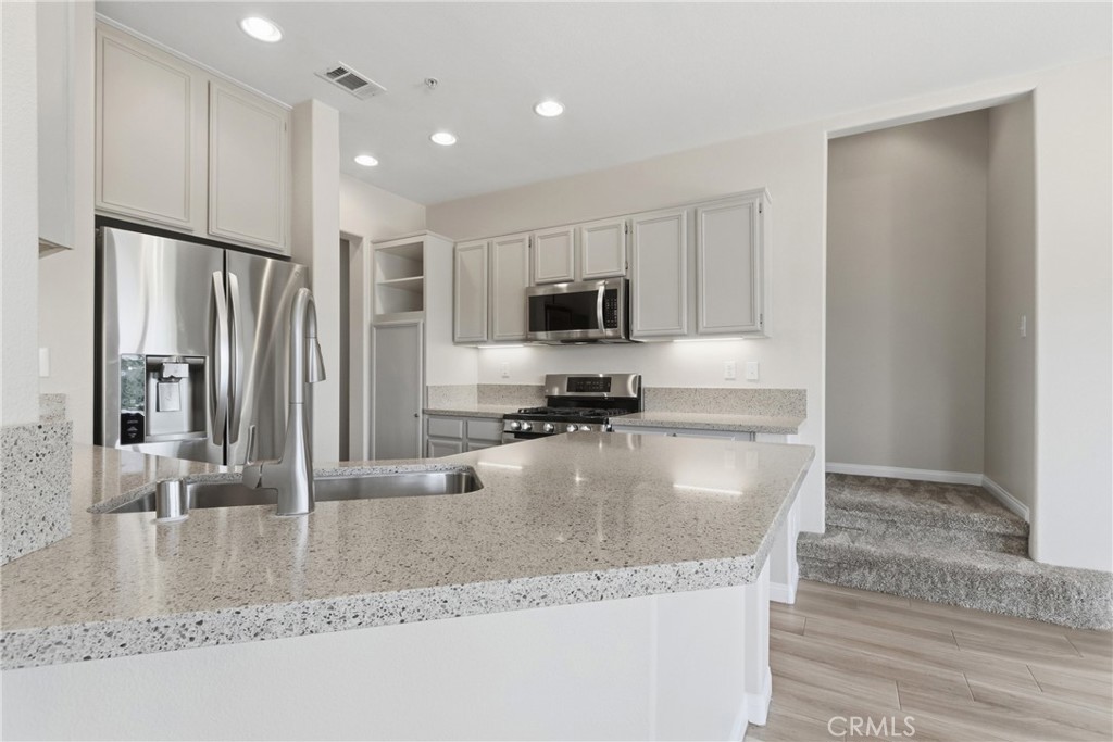 33576 Winston Way, Unit A Temecula, CA 92592 - Photo 10 of 44 a large kitchen with granite countertop a refrigerator a stove and a sink