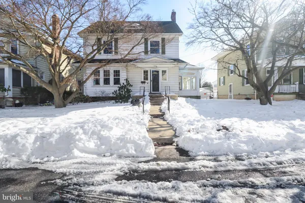 a front view of a house with a yard covered in snow