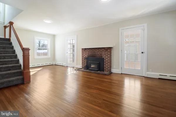 a view of a livingroom with wooden floor and a fireplace