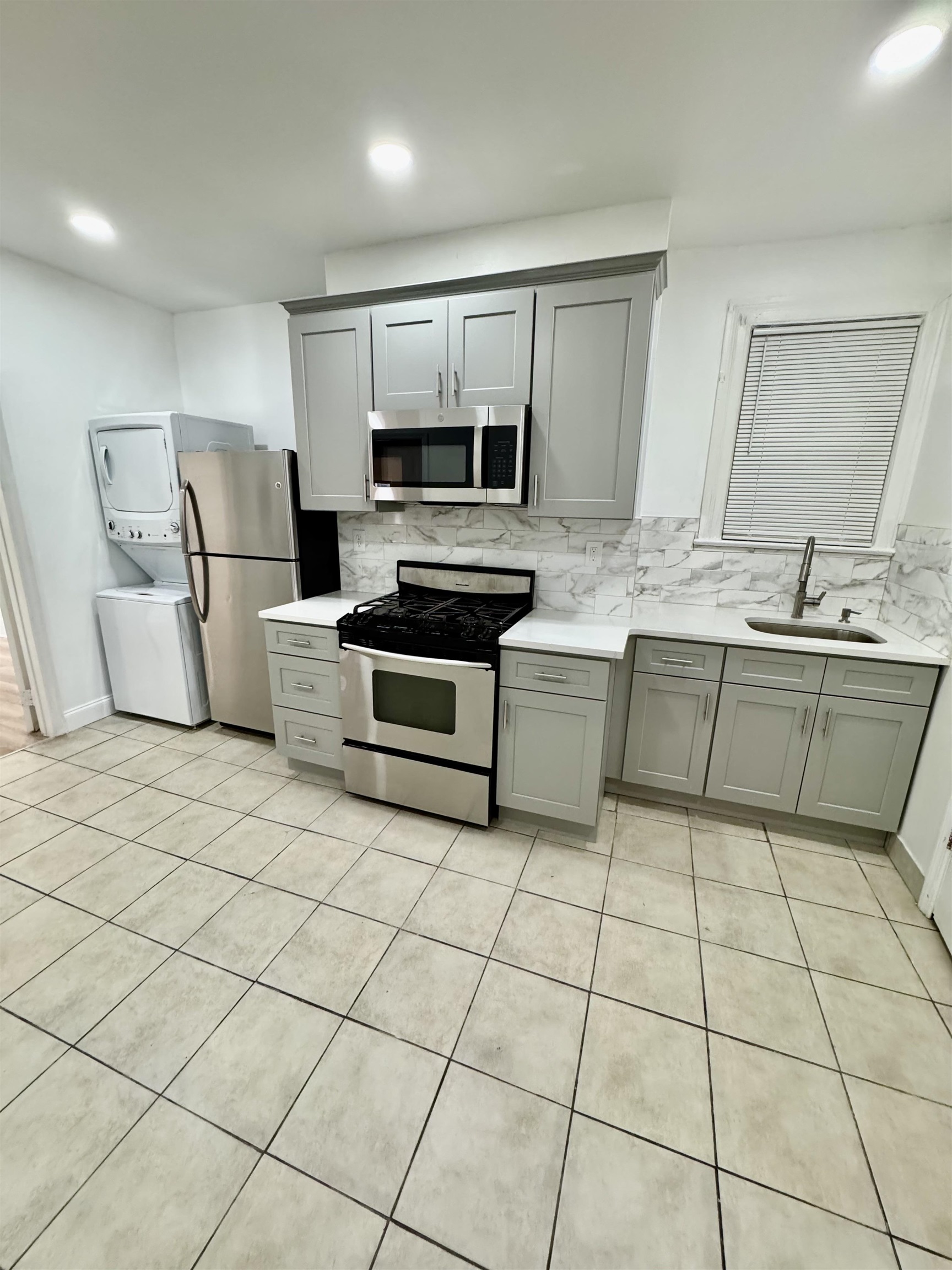 204 Zabriskie Street, Unit 1 & G Jersey City, NJ 07307 - Photo 2 of 21 a kitchen with a sink a stove a microwave and cabinets