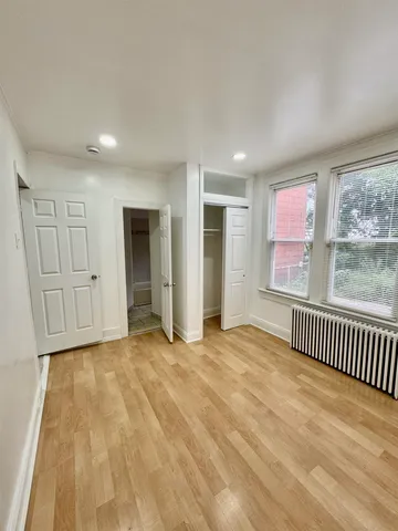 a view of empty room with wooden floor