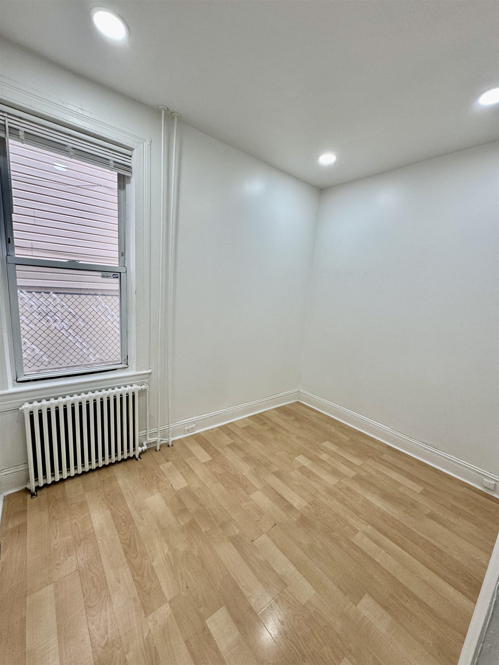 204 Zabriskie Street, Unit 1 & G Jersey City, NJ 07307 - Photo 8 of 21 a view of an empty room with wooden floor and a window