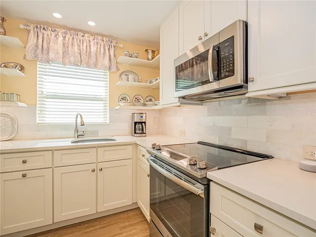 a kitchen with stainless steel appliances white cabinets and a sink