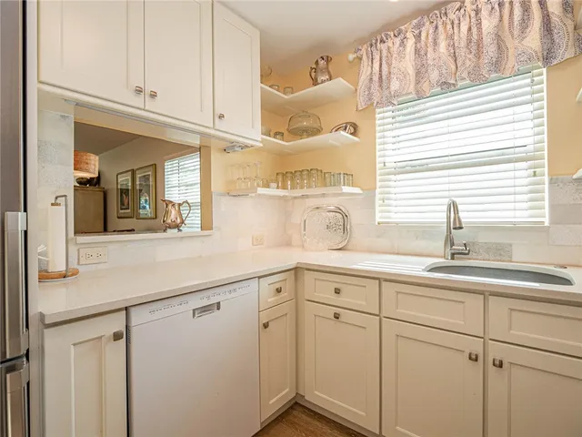 a kitchen with white cabinets and a sink