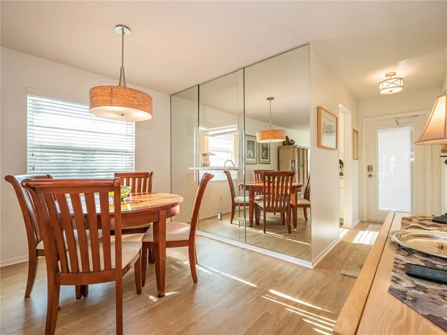 a dining room with furniture a chandelier and wooden floor