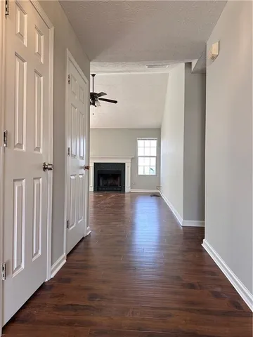 a view of empty room with wooden floor and fireplace