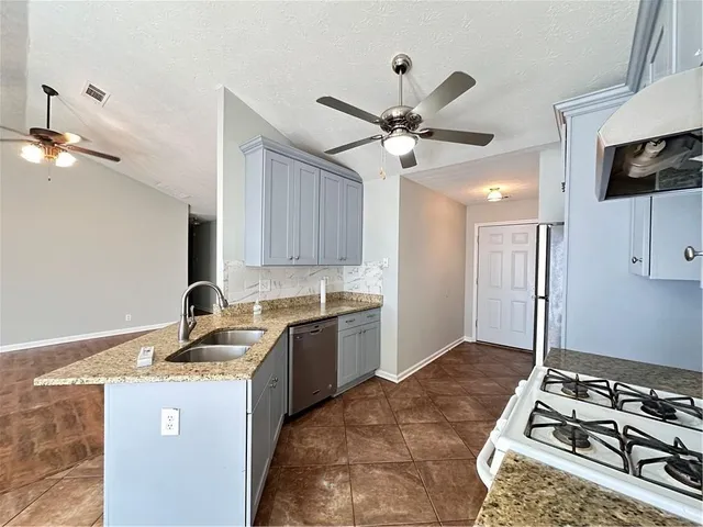 a kitchen with a stove a sink and a refrigerator