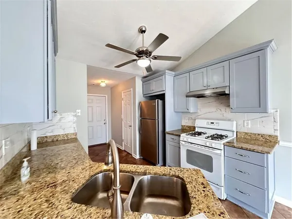 a kitchen with stainless steel appliances granite countertop a sink stove and refrigerator