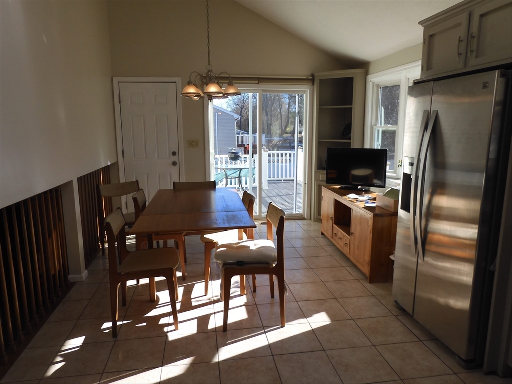 115 Merrimack Road, Unit 115 Methuen, MA 01844 - Photo 11 of 23 a kitchen with stainless steel appliances granite countertop a refrigerator a stove a sink a dining table and chairs