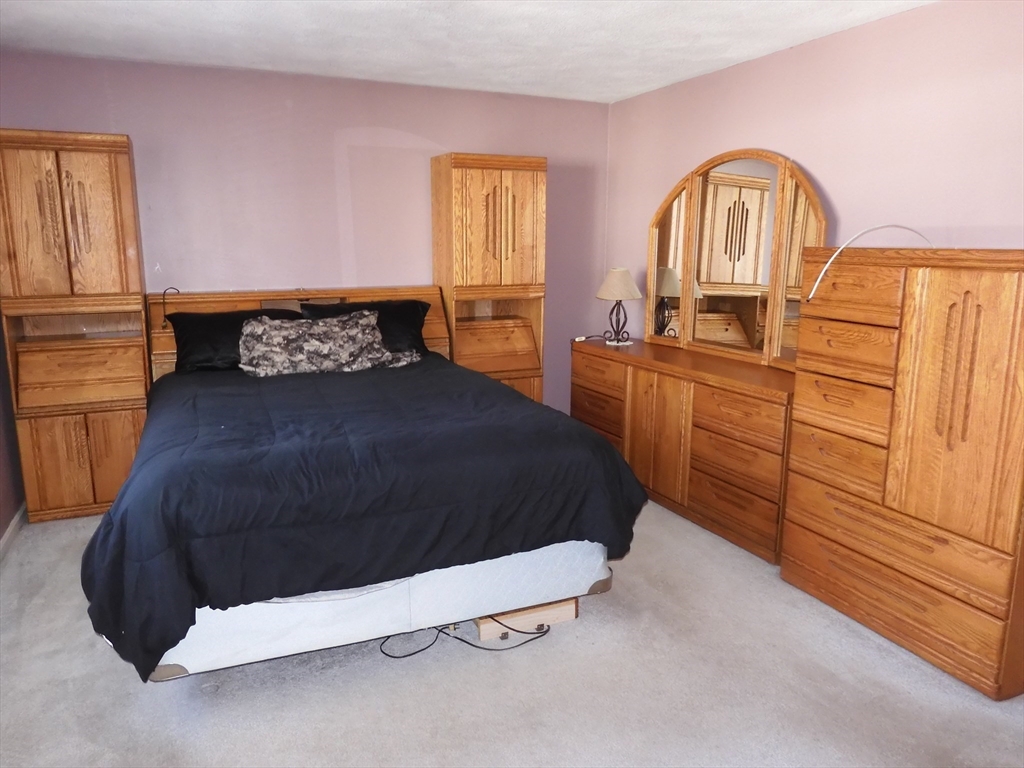115 Merrimack Road, Unit 115 Methuen, MA 01844 - Photo 14 of 23 a bedroom with a bed and a dresser