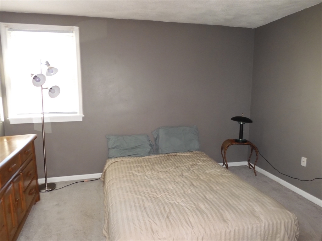 115 Merrimack Road, Unit 115 Methuen, MA 01844 - Photo 16 of 23 a bedroom with a bed and a window