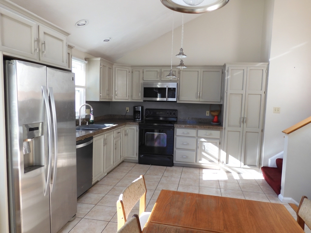 115 Merrimack Road, Unit 115 Methuen, MA 01844 - Photo 5 of 23 a kitchen with kitchen island granite countertop a refrigerator oven a sink and dishwasher