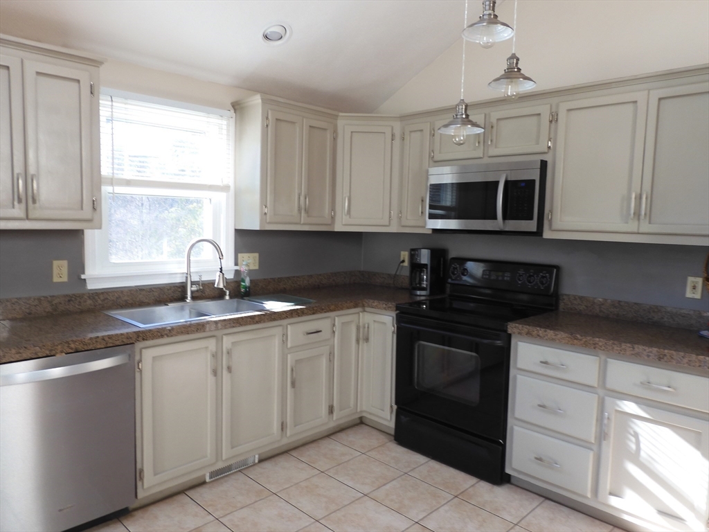 115 Merrimack Road, Unit 115 Methuen, MA 01844 - Photo 6 of 23 a kitchen with cabinets stainless steel appliances and a sink