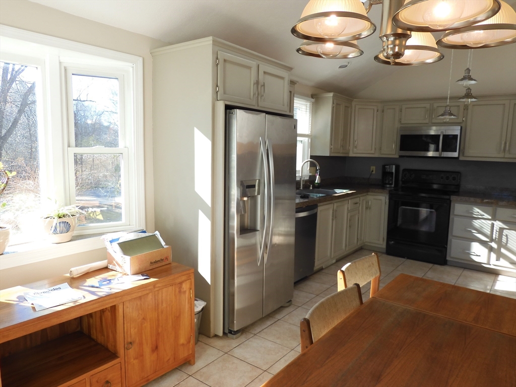 115 Merrimack Road, Unit 115 Methuen, MA 01844 - Photo 9 of 23 a kitchen with stainless steel appliances granite countertop a refrigerator a sink a stove and island