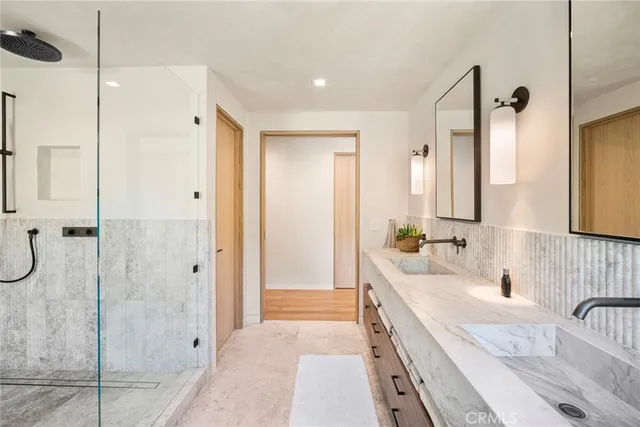 a bathroom with a double vanity sink mirror and bathtub