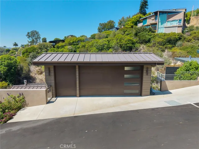 an aerial view of a house with swimming pool and large trees