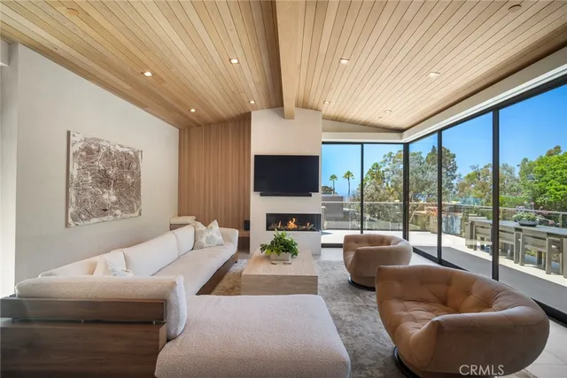 a living room with furniture a flat screen tv and a floor to ceiling window