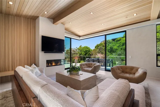 a living room with furniture a flat screen tv and a large window