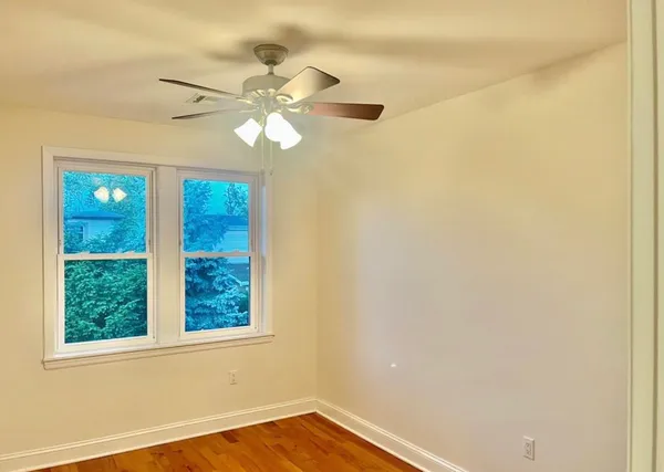 an empty room with a window and a fan