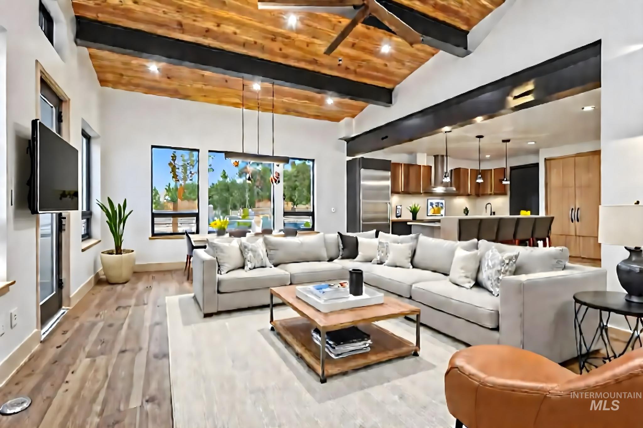 Living area with ceiling fan, light wood finished floors, a wood ceiling with exposed beams, and recessed lighting