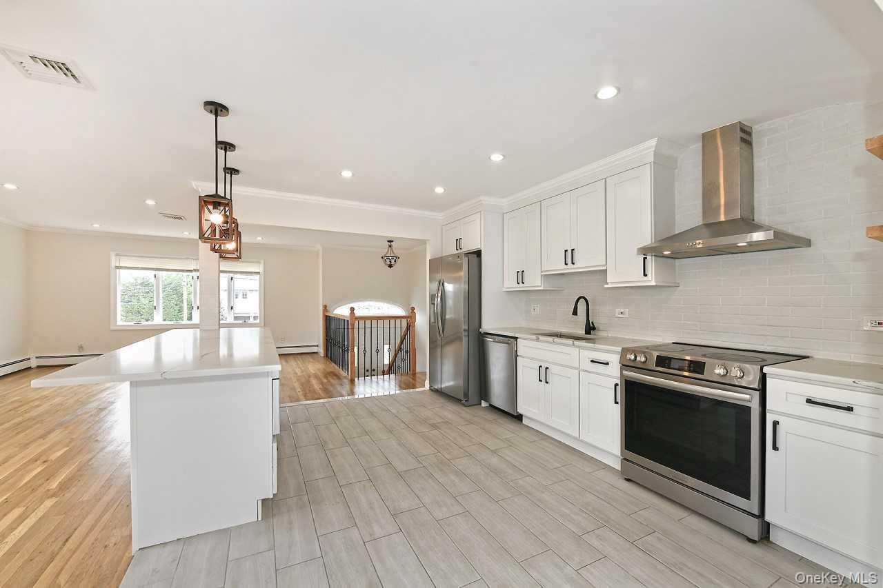 107 Beverly Road Massapequa, NY 11758 - Photo 8 of 41 a kitchen with stainless steel appliances a stove sink and cabinets
