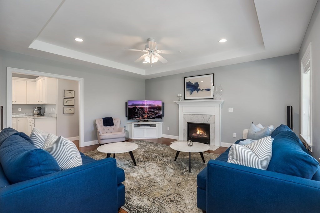 2 Budnick Way Boxford, MA 01921 - Photo 13 of 41 a living room with furniture a fireplace and a flat screen tv