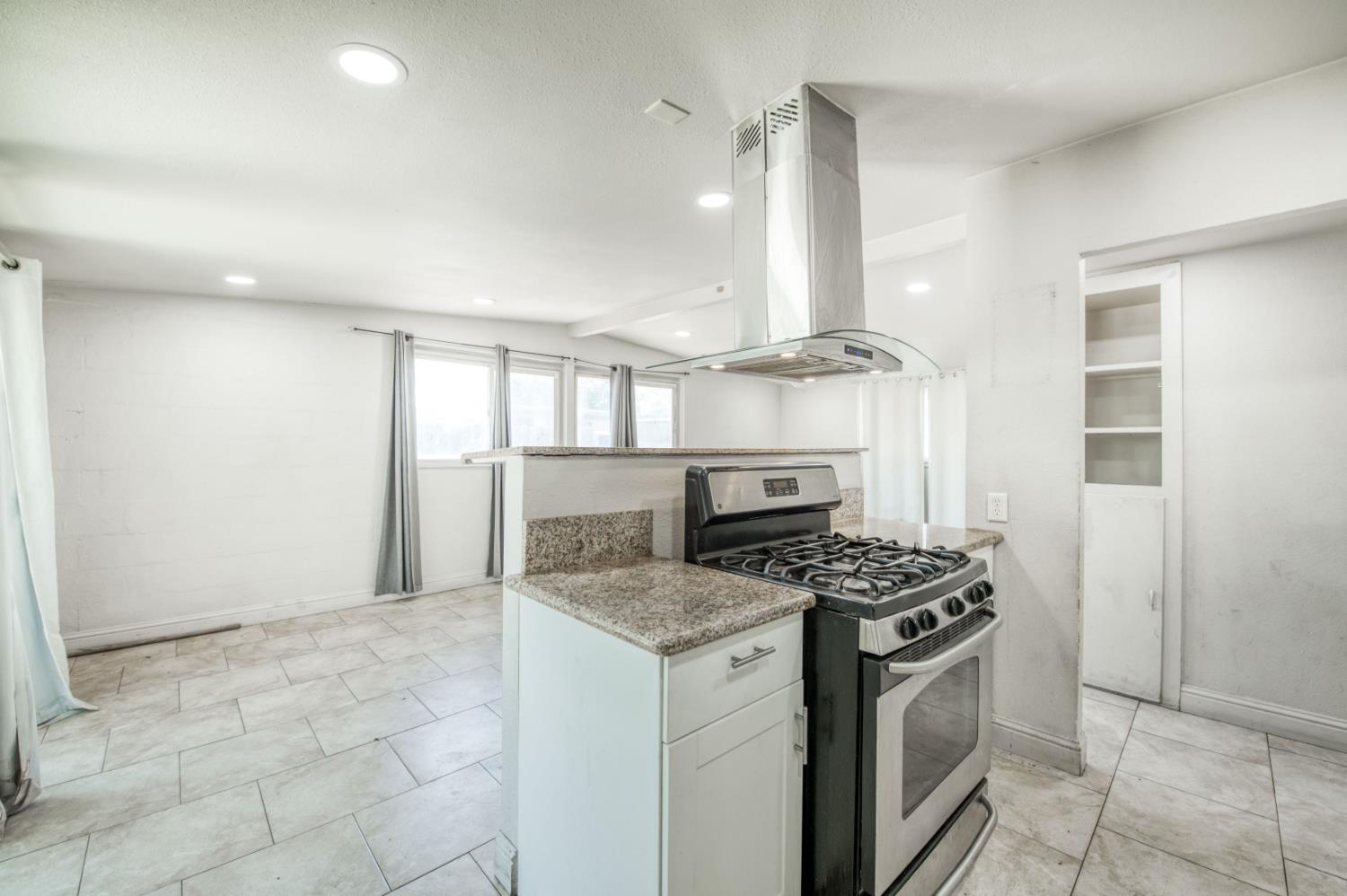 2326 East Hampton Way Fresno, CA 93726 - Photo 8 of 22 a kitchen with stainless steel appliances granite countertop a stove a sink and a refrigerator