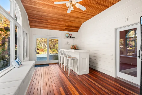 a view of a hallway with wooden floor and furniture