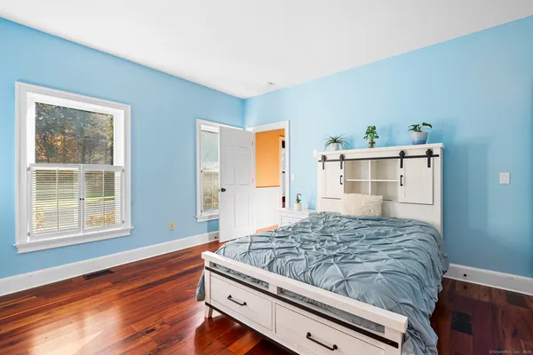 a bedroom with a bed and wooden floor