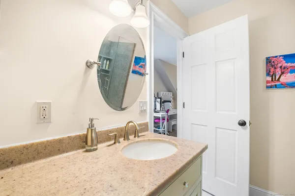a bathroom with a granite countertop sink and a mirror